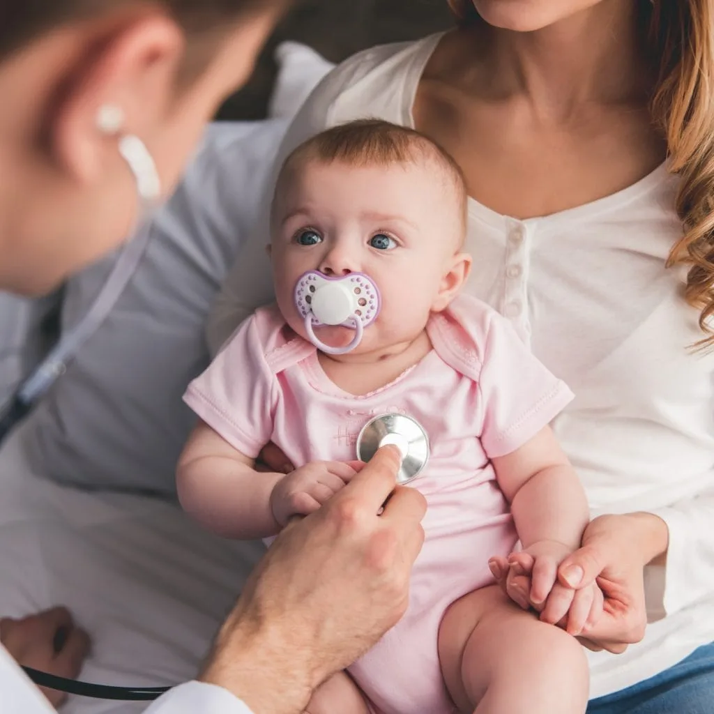 Un pediatra esamina una bambina piccola