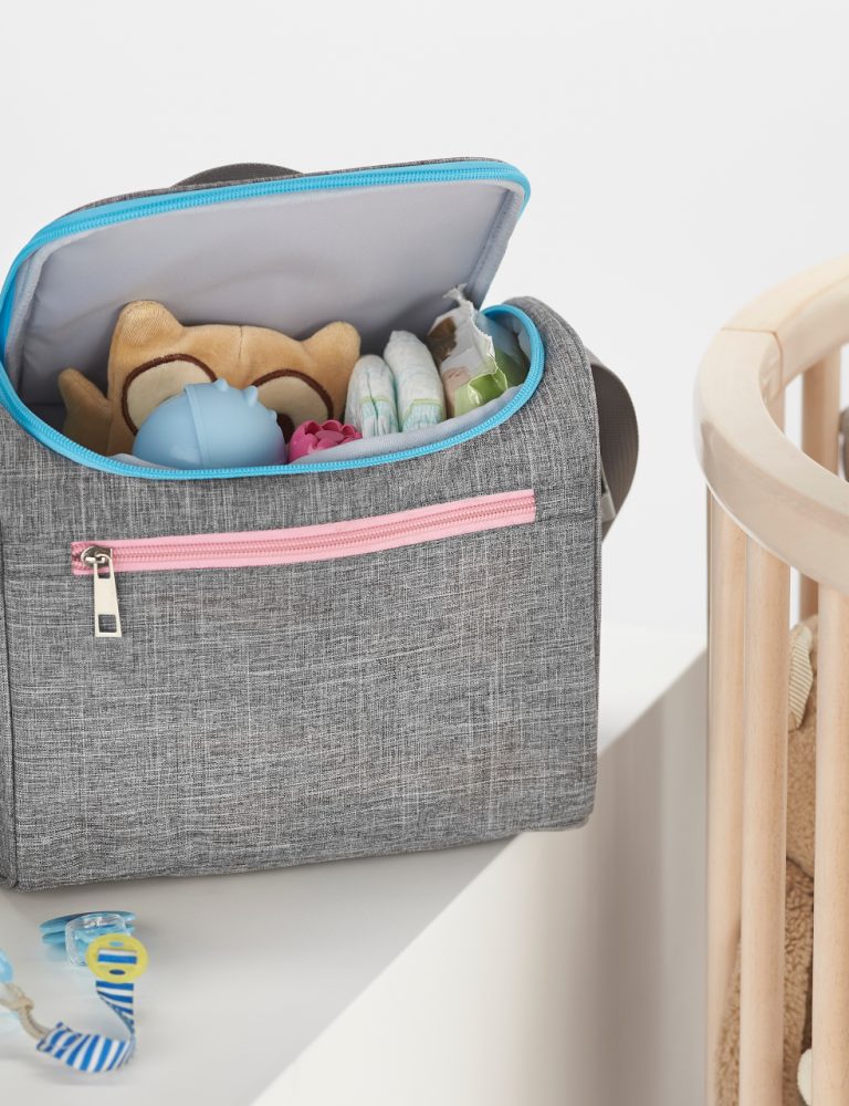 Nosiboo Bag Baby Organizer on a shelf next to the baby cot bed and filled with baby accessories